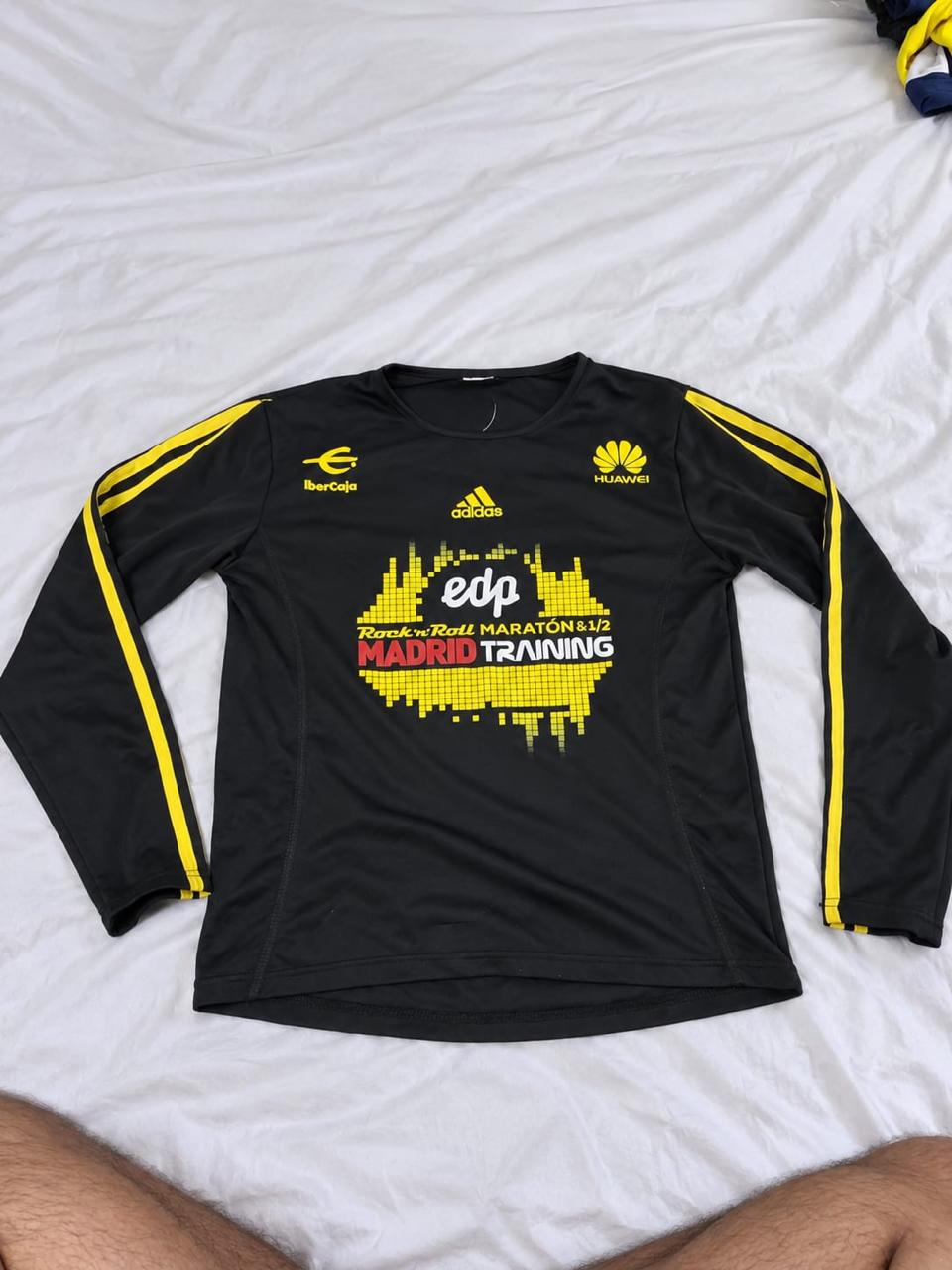 Black and yellow long sleeve football training top shown from the front